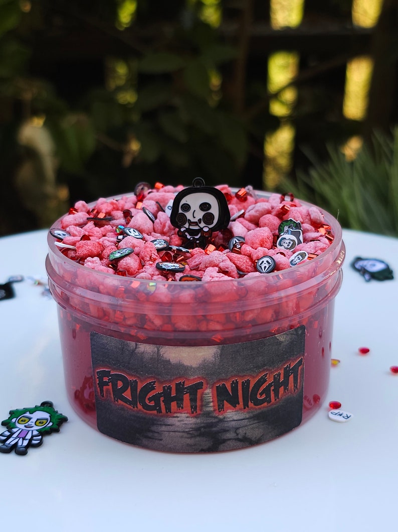 May include: Red slime with a black and white horror character charm, red and white sprinkles, and a black label that says "FRIGHT NIGHT".