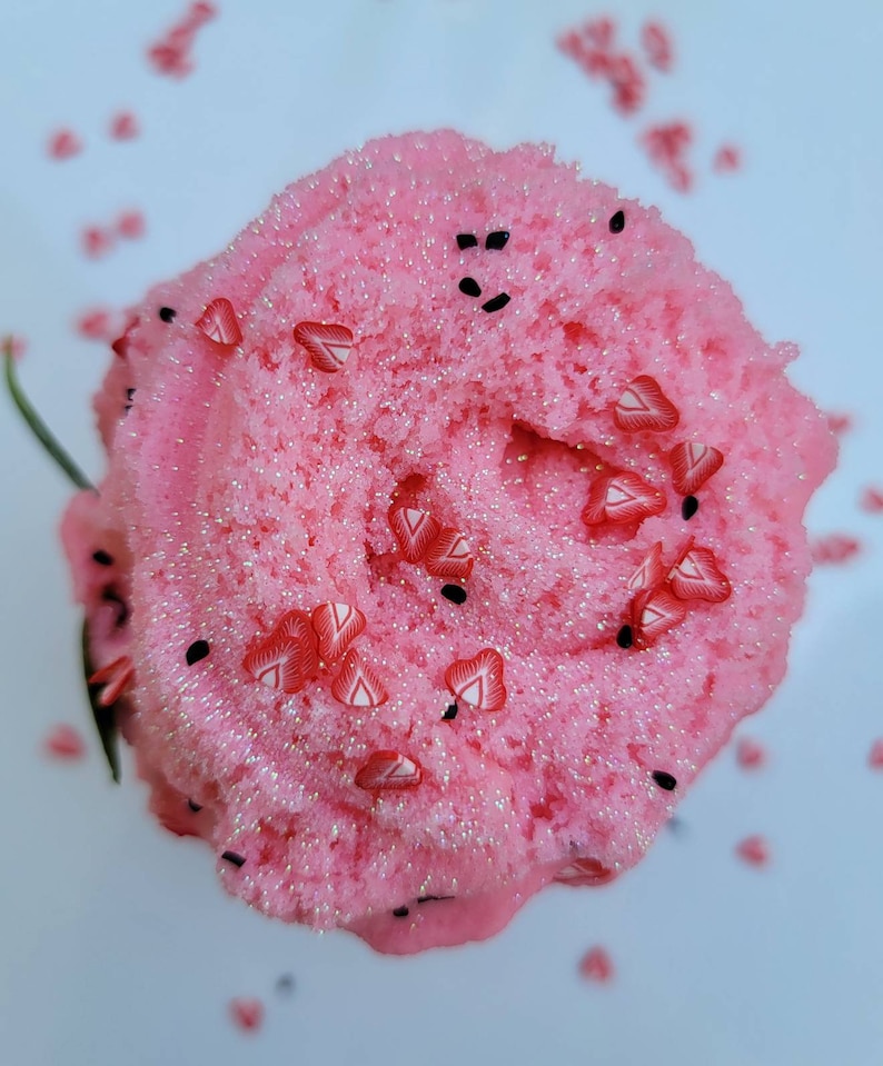 Peut inclure: Slime rose avec des paillettes et des p&eacute;pites en forme de c&oelig;ur rouges. Le slime est dans un r&eacute;cipient transparent et repose sur une surface blanche.