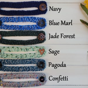 Op de afbeelding: Zes gebreide maskerverlengers in verschillende kleuren en patronen, waaronder marineblauw, blauw marmer, jadebos, salie, pagode en confetti. Elke verlenging heeft twee knopen aan de uiteinden.