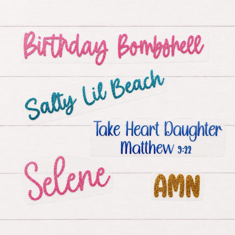 May include: Five separate adhesive decals featuring glittery text. The top decal reads Birthday Bombshell in pink, followed by Salty Lil Beach in teal, Take Heart Daughter Matthew 9:22 in blue, Selene in pink, and the letters AMN in gold glitter.