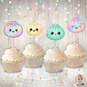 May include: Four cupcakes with white frosting, each topped with a decorative paper topper featuring a cartoon dumpling character. The dumplings have smiling faces and come in iridescent rainbow, solid cream, glittery teal, and purple colors.