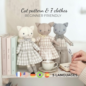 Può includere: Tre bambole a forma di gatto fatte a mano con abiti diversi. Le bambole sono bianche, beige e grigie, ognuna con un abito o pantaloni e camicia a quadri unici. Il testo sull'immagine dice "Cat pattern & 7 clothes BEGINNER FRIENDLY".