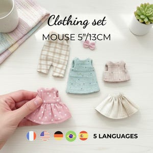 May include: A clothing set for a 13cm mouse doll, including a beige plaid romper, a light green dress with gold dots, a pink dress with white dots, a pink plaid vest, a cream skirt, and a small pink bow accessory. Text reads: Clothing set MOUSE 5"/13CM.