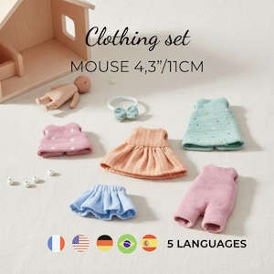 May include: Clothing set for an 11cm mouse doll, including a pink sweater, a peach dress, a light blue skirt, a mint green top with gold dots, pink trousers, and a small bow headband. The set also features a small wooden doll figure.