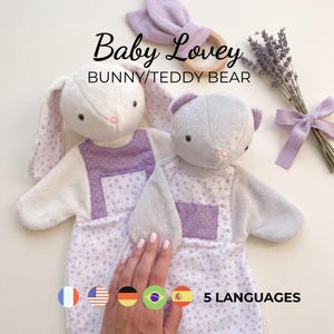 May include: Two plush baby loveys, one bunny and one teddy bear, featuring soft cream and grey fabric with purple floral and polka dot accents. The text Baby Lovey BUNNY/TEDDY BEAR is visible above the toys, alongside a wooden ring and lavender.