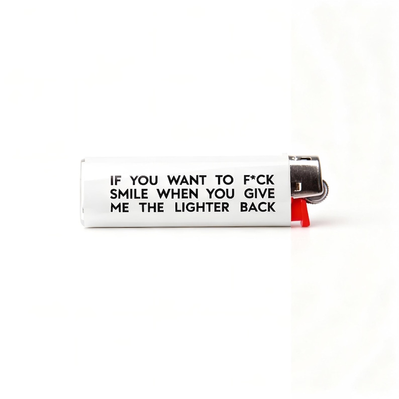 Pu&ograve; includere: Accendino bianco con testo nero: "IF YOU WANT TO F*CK SMILE WHEN YOU GIVE ME THE LIGHTER BACK." L'accendino ha un pulsante di accensione rosso e una parte superiore in metallo.