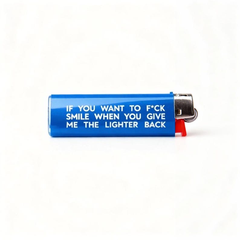 Pu&ograve; includere: Un accendino blu con la scritta "IF YOU WANT TO F*CK SMILE WHEN YOU GIVE ME THE LIGHTER BACK". Ha una parte superiore in metallo argentato e una leva di accensione rossa.