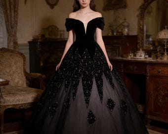 May include: A black off-the-shoulder ball gown with a velvet bodice and a full skirt. The skirt features a geometric pattern of sparkling embellishments and diamond-shaped accents. The dress has a plunging neckline and a layered tulle skirt.