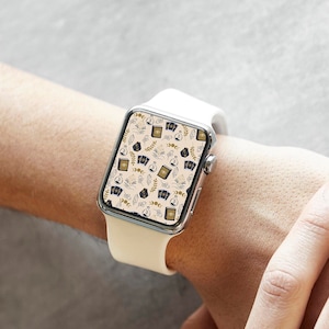 May include: A white Apple Watch with a white band. The watch face has a pattern of black and gold icons.