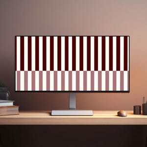 May include: A computer monitor displays a striped pattern in burgundy, white, and mauve. The monitor sits on a wooden desk with a lamp, a small potted plant, and office supplies. The overall theme is modern office decor.