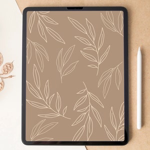 Può includere: Un tablet digitale mostra un motivo a foglie beige sullo schermo, con uno stilo bianco accanto. Il tablet è ambientato su uno sfondo neutro, con elementi floreali secchi che aggiungono un tocco naturale. L'estetica generale è minimalista e moderna.