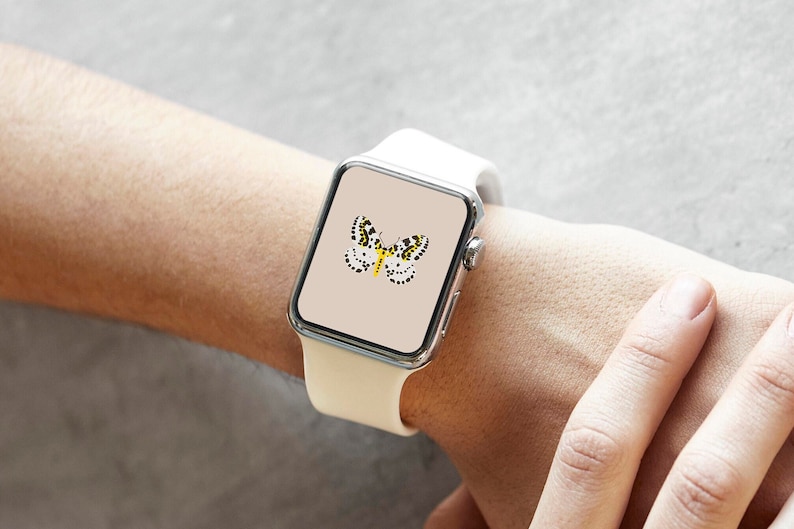 Może przedstawiać: Biały smartwatch z motywem motyla na ekranie. Motyl ma czarne i ż&oacute;łte plamki oraz ż&oacute;łte ciało. Zegarek jest na nadgarstku.