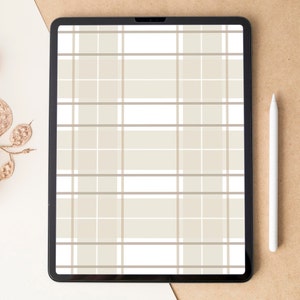 Puede incluir: Una tableta digital con marco negro muestra un patrón de cuadros beige y blanco. Un lápiz óptico blanco descansa sobre una superficie marrón junto a la tableta. Follaje seco de color dorado a la izquierda.