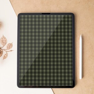 Puede incluir: Una tableta negra con un patrón de cuadros verdes y negros en la pantalla. Un lápiz óptico blanco está colocado verticalmente a la derecha de la tableta. El fondo es una mezcla de blanco y beige.