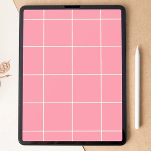 Puede incluir: Una tableta negra con una pantalla de cuadrícula rosa y un lápiz óptico blanco descansa sobre una superficie de tonos neutros. Follaje decorativo seco de color dorado se encuentra en la esquina superior izquierda. La pantalla de la tableta está dividida en cuadrados rosas por líneas blancas.
