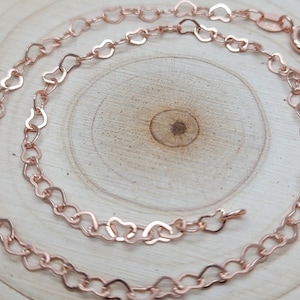 May include: A rose gold heart-shaped chain necklace. The chain is made of small, delicate hearts linked together.