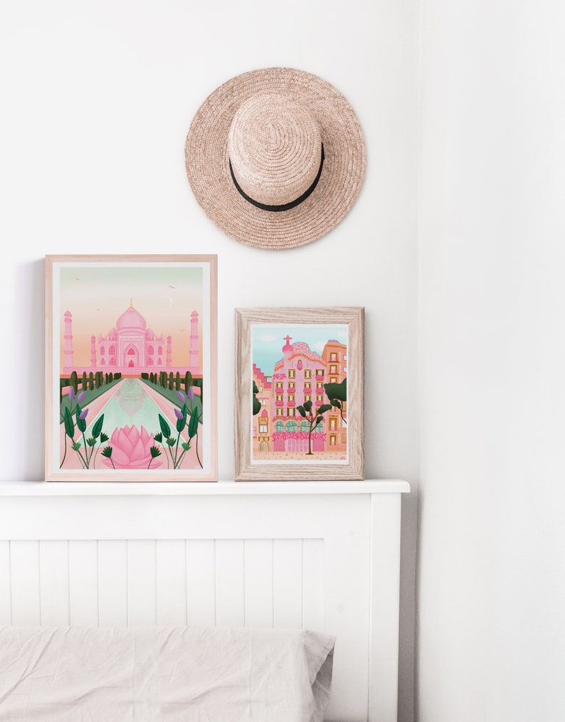May include: Two framed illustrations of buildings. The first illustration is of the Taj Mahal in pink and white with a reflecting pool in the foreground. The second illustration is of a pink building with a green tree in front of it.