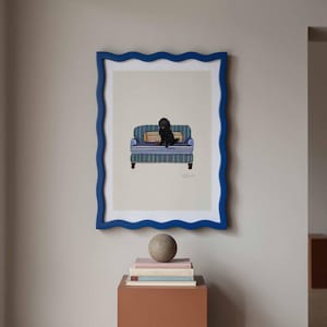 Peut inclure: Une impression encadrée d'un chien noir assis sur un petit canapé à rayures bleues. Le cadre bleu a des bords ondulés. Une pile de livres et une sphère en pierre reposent sur un piédestal marron en dessous.