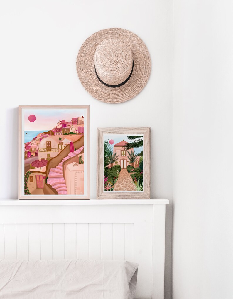 May include: Two framed illustrations of pink buildings with a white background. The top illustration shows a pink building with a pink staircase and a pink umbrella. The bottom illustration shows a pink building with a green garden and a stone path.