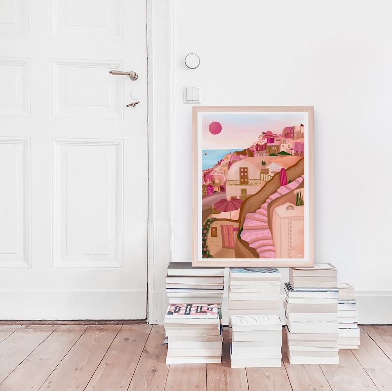 May include: A framed illustration of a pink and brown cityscape with a pink sun in the sky. The cityscape is on a hillside with a set of pink stairs leading up to the top.