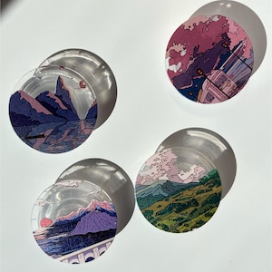 Puede incluir: Cuatro posavasos redondos y transparentes con diseños de paisajes. Cada posavasos presenta una escena diferente: montañas, agua y una puesta de sol. Los posavasos están hechos de un material transparente, con el arte del paisaje impreso en la parte inferior.