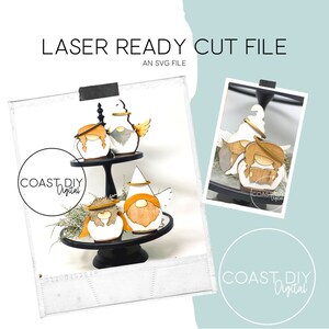 May include: Laser cut SVG file for a tiered tray featuring three gnomes with halos and wings. The gnomes are painted white with brown beards and hats, and have gold halos and wings. The gnomes are on a black tiered tray with a white background.