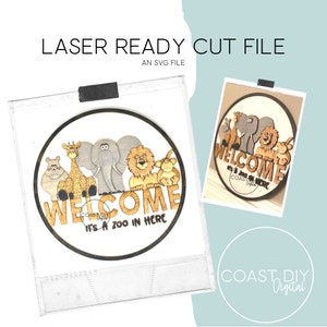 May include: A laser cut wooden welcome sign with a circle design featuring a giraffe, elephant, lion, and monkey. The sign reads "Welcome It's a Zoo in Here".