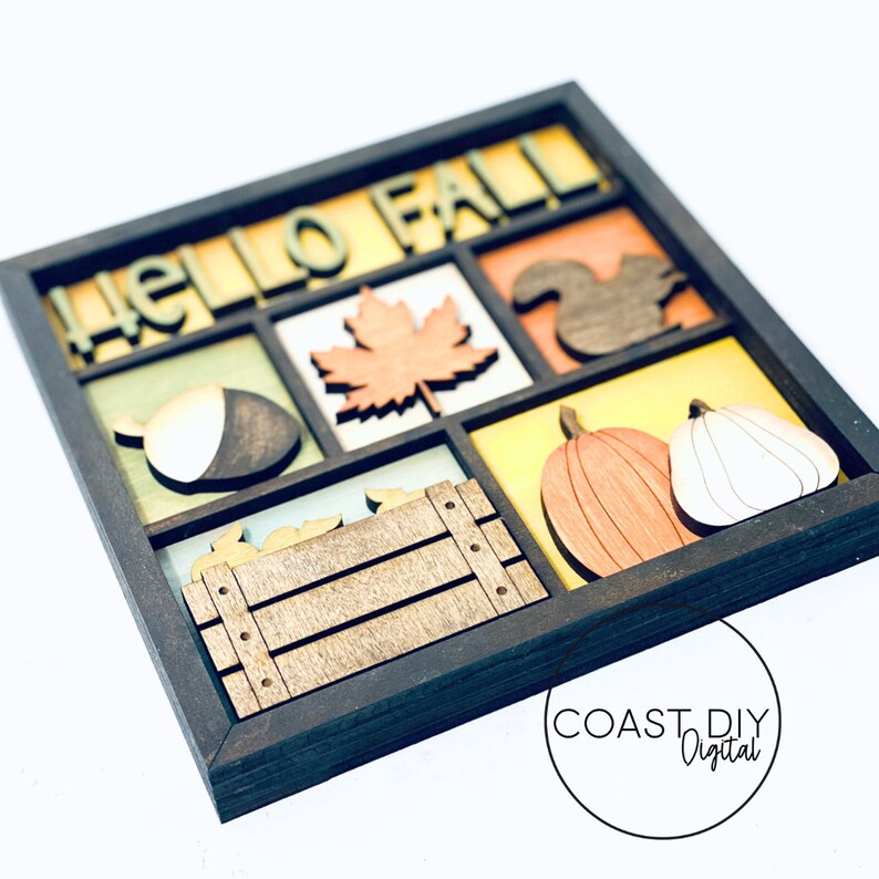 May include: A wooden framed wall decor with the words "Hello Fall" in a multi-colored font. The frame is divided into nine sections, each containing a different fall-themed image, including a leaf, an acorn, a squirrel, a pumpkin, and a crate.