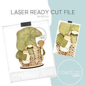 May include: A laser-cut SVG file of a gnome holding a jar and a wooden spoon. The gnome is wearing a green hat and has a long braid. The file is ready to be cut on a laser cutter.