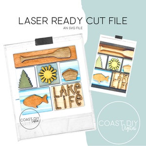 Könnte beinhalten: Eine digitale Schnittdatei für einen Laserschneider, mit einer Reihe von SVG-Designs zum Thema See. Die Designs beinhalten ein Paddel, eine Sonne, ein Boot, einen Fisch, eine Kiefer und die Worte "Lake Life".
