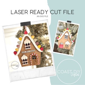 May include: A wooden gingerbread house ornament with a red roof, white trim, and candy cane accents. The house has a sign that reads "Singer's Bread & Breakfast".