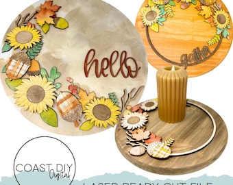 May include: Three decorative wooden fall-themed items. A round sign with sunflowers, acorns, and the word "hello". A round sign with sunflowers and the word "gather". A wooden tray with a candle and fall decor. The text "COAST.DIY Digital" and "LASER READY CUT FILE" are also visible.