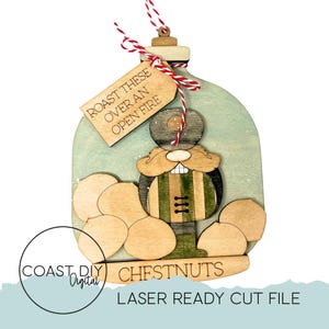 May include: Wooden Christmas ornament featuring a gnome with a mustache and a green and brown outfit. The ornament has a tag that says "ROAST THESE OVER AN OPEN FIRE" and the word "CHESTNUTS" at the bottom. The ornament is laser-cut.