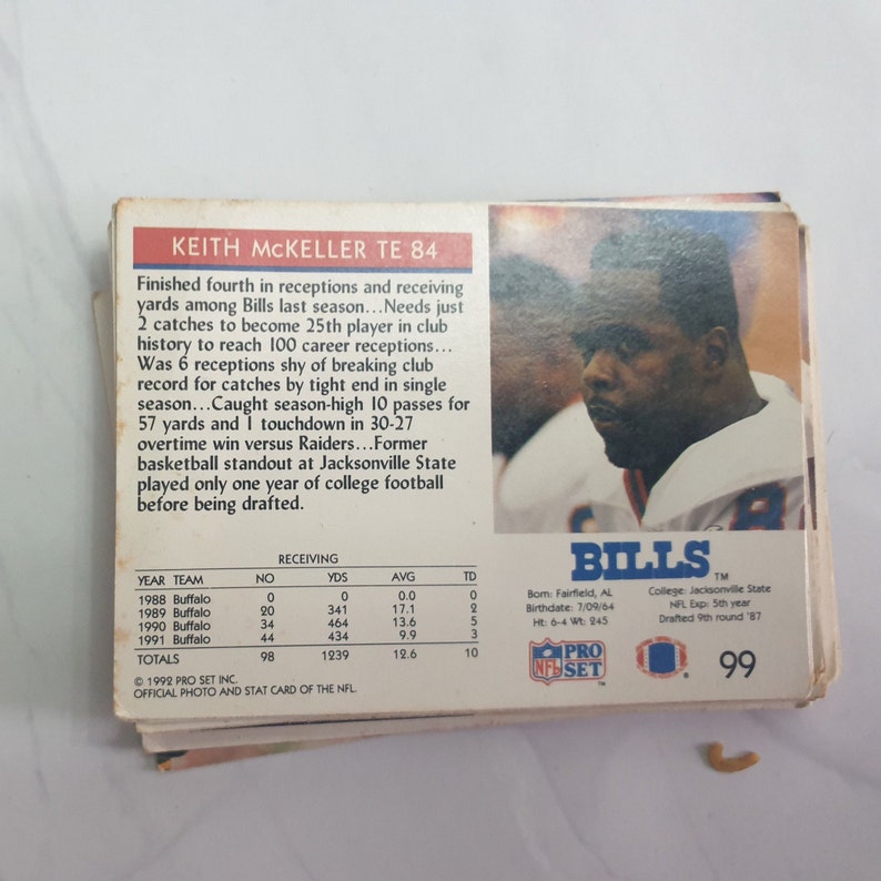 May include: A 1992 Pro Set NFL trading card featuring Keith McKeller, a tight end for the Buffalo Bills. The card is blue and white with a photo of McKeller in his Bills uniform. The card number is 99.
