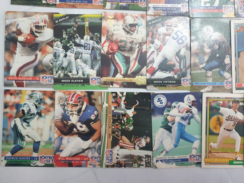 May include: A collection of 11 trading cards featuring NFL players from the 1990s. The cards are in various colors, including red, blue, green, and white. The cards feature players from teams such as the Detroit Lions, the Houston Oilers, and the Buffalo Bills. The cards are in good condition and would be a great addition to any sports card collection.