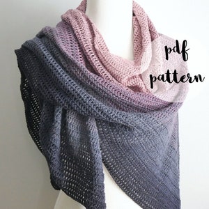 May include: A crocheted shawl in a gradient of colours, from pink to grey, draped over a mannequin. The shawl is a triangular shape with a textured stitch pattern. Text on the image reads "pdf pattern" and "fiber flux".
