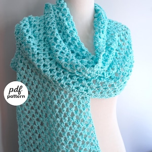 May include: A light turquoise crochet scarf with an openwork stitch pattern draped over a mannequin. A circular white graphic on the left displays the text pdf pattern, and a circular white graphic on the bottom right displays the text fiber flux.