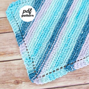 May include: A knitted square in shades of blue, turquoise, and lavender, with a diagonal striped pattern. The edges have a decorative border. The words "pdf pattern" are in a white circle in the upper left corner, and "fiber flux" is in a circle in the lower right corner.