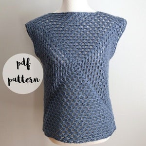 Puede incluir: Un top de ganchillo azul exhibido en un maniquí. El top tiene un diseño de tejido suelto y abierto y un cuello barco. Las palabras "pdf pattern" están en un círculo blanco. La marca "FIBER flux" está en la parte inferior.