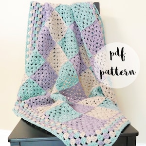 May include: A crochet baby blanket in shades of teal, purple, and beige. The blanket is made with granny squares and is draped over a black chair. The text "pdf pattern" is written in white on a white circle.