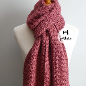 Könnte beinhalten: Ein gehäkelter Schal in einem tiefen Rosaton, der auf einem weißen Mannequin präsentiert wird. Der Schal ist mit einem strukturierten Stichmuster gearbeitet und hat ein schlichtes, elegantes Design. Der Text "pdf pattern" ist auf dem Bild sichtbar.