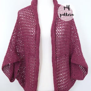 Puede incluir: Un cárdigan de ganchillo burdeos con un patrón de encaje. El cárdigan está abierto por delante y tiene un escote amplio y abierto. El texto "pdf pattern" es visible en la imagen.