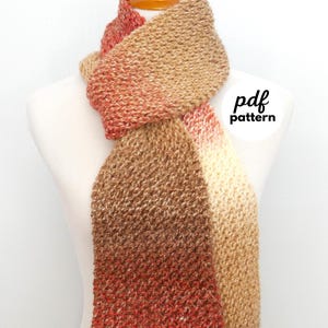 May include: A hand-knitted scarf in shades of brown, beige, and red, displayed on a mannequin. The scarf features a textured stitch pattern and a color gradient. The text "pdf pattern" is visible.
