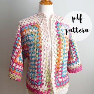 Op de afbeelding: Een gehaakt vest met een granny square patroon in tinten roze, oranje, groen, blauw en wit. Het vest is open aan de voorkant en heeft korte mouwen. De tekst "pdf pattern" is zichtbaar in de afbeelding.