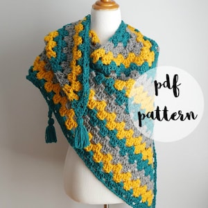 May include: A teal, gray, and yellow crochet shawl with fringe. The shawl is draped over a mannequin. The text "pdf pattern" is on a white circle.
