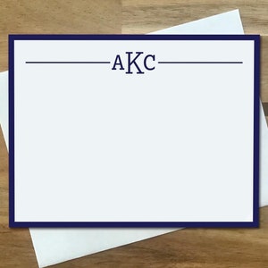 May include: A white card with a navy blue border and the letters "AKC" printed in navy blue.