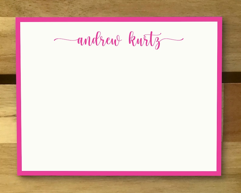May include: A white card with a pink border and the name "andrew kurtz" written in pink cursive.