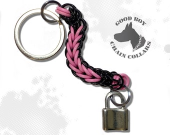 May include: Pink and black braided keychain with a silver padlock and a silver key ring. The keychain has a logo tag that says "Good Boy Chain Collars".
