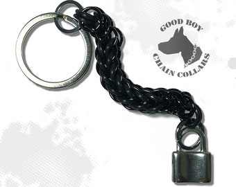 May include: Black chain keychain with a silver padlock and a silver key ring. The chain has a logo tag that reads "GOOD BOY CHAIN COLLARS".