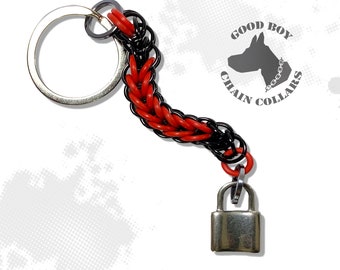May include: A red and black chain keychain with a silver padlock attached. The keychain has a silver ring for attaching keys. The keychain is labeled "Good Boy Chain Collars".